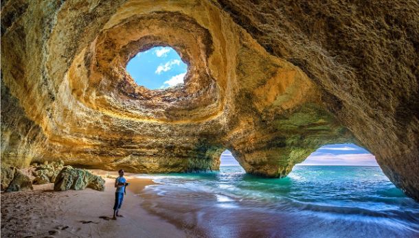 man inside open beach caverns in portugal